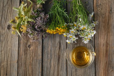 Bir bardak papatya çayı bir cam bardak ve bir buket alan toplamı