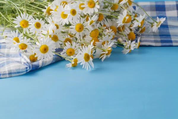 Ramo de flores silvestres en la mesa azul al atardecer — Foto de Stock