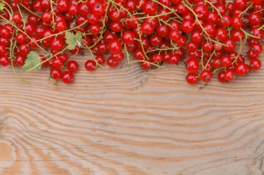 Çilek kırmızı kuş üzümü ve kahverengi ahşap doku üstünde laptop