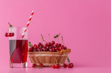 cherry juice in a glass and pitcher on pink with ripe berries in clipart