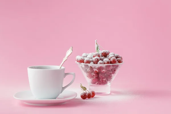 Cereza silvestre en un plato con una taza de café en un rosa — Foto de Stock