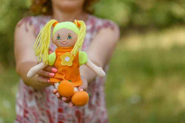 Woman in dress holding doll at her waist, dreaming of having a b — Stock Photo, Image