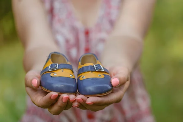 Mujer embarazada vientre sosteniendo botines de bebé. Embarazo saludable . — Foto de Stock