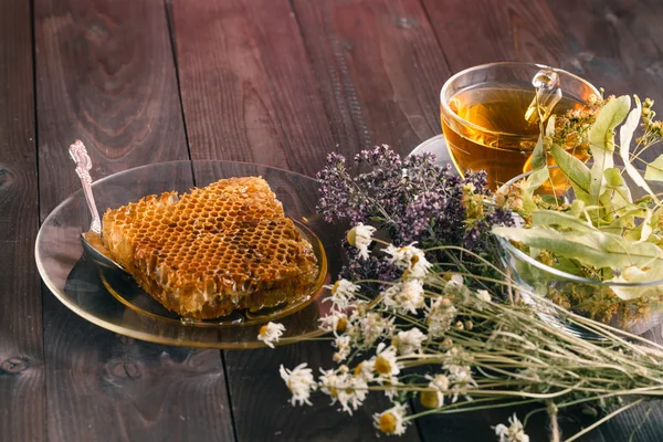 Golden honeycomb with honey and tea linden flowers on wooden bac — Stock Photo, Image