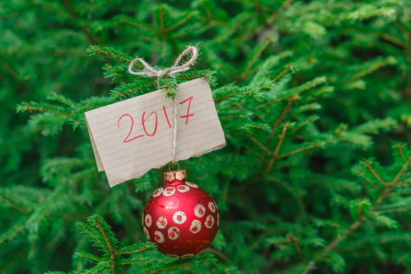 Bir dal yeşil çam üzerinde asılı büyük kırmızı Noel top — Stok fotoğraf