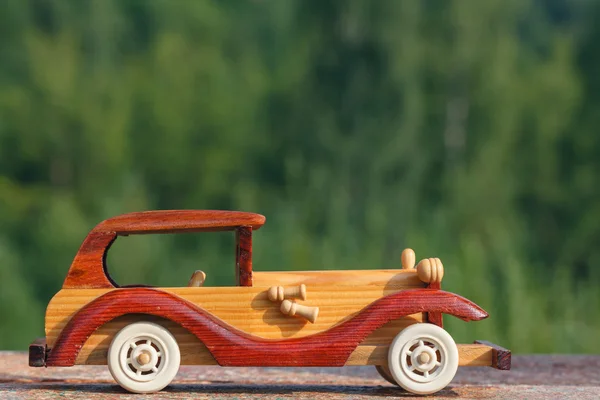 Wooden toy car on a rustic surface — Stock Photo, Image