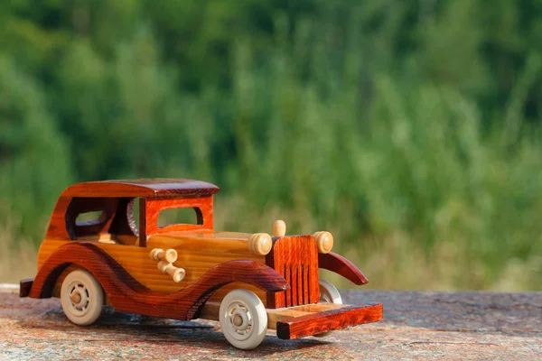Wooden toy car on a rustic surface — Stock Photo, Image