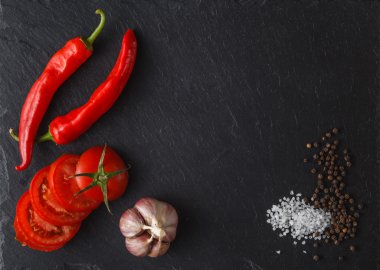 Baharatlar, üstten görünüm siyah bir zemin üzerine domates kesmek