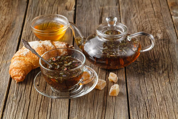 Colazione con tisana e croissant sul tavolo vintage in legno — Foto Stock