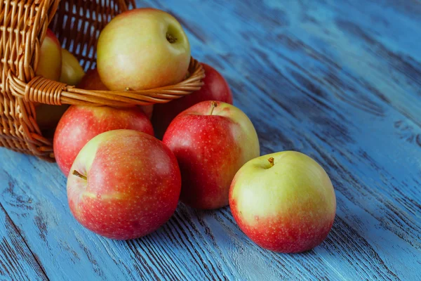 Cesta de mimbre llena de manzanas rojas de gala sobre fondo rústico de madera — Foto de Stock