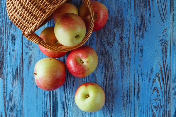 Manzanas en una canasta sobre fondo de madera. Espacio libre para texto — Foto de Stock