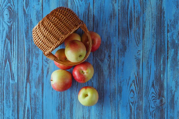 Manzanas en una canasta sobre fondo de madera. Espacio libre para texto — Foto de Stock