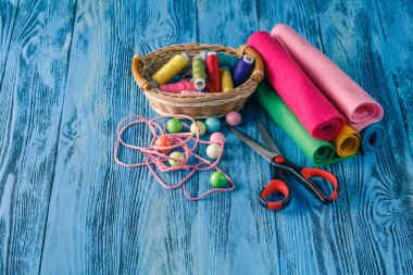 Ahşap bir masa üzerinde dikiş takımı. Tel, iğneler, makas ve bir için