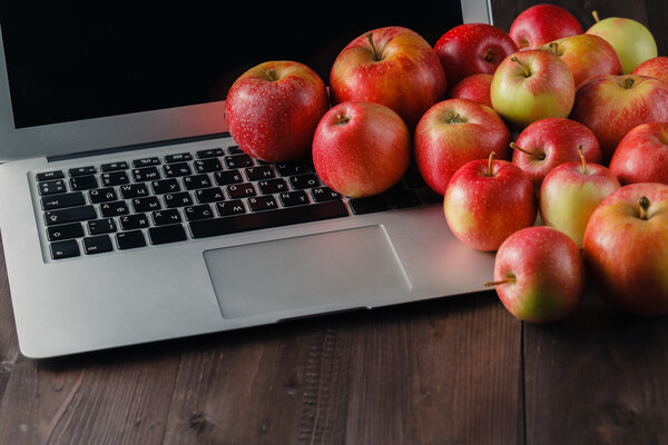 Ноутбук и яблоки на столе
