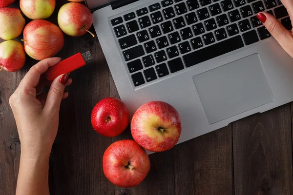 Primo piano di una donna mano spina pendrive rosso su un computer portatile — Foto Stock