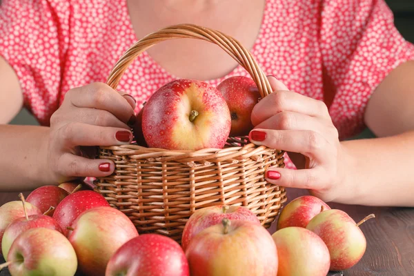 Mujer sosteniendo una cesta de manzanas — Foto de Stock
