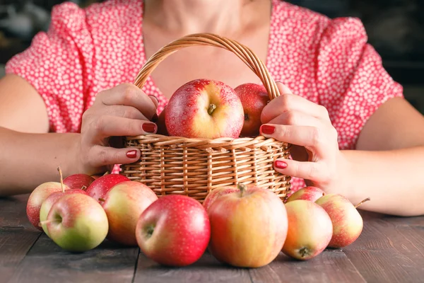 Mujer sosteniendo una cesta de manzanas — Foto de Stock
