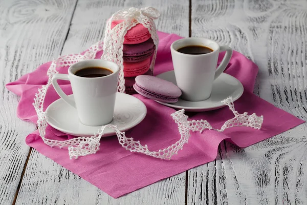 Zwei Tassen Espresso mit Makronen auf rosa Hintergrund — Stockfoto