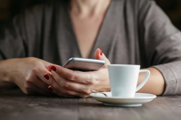 Kézi nő telefon és csésze kávé — Stock Fotó