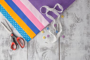 Dikiş, örgü ve tığ işi aksesuarlar. Kumaş, ahşap masa. 