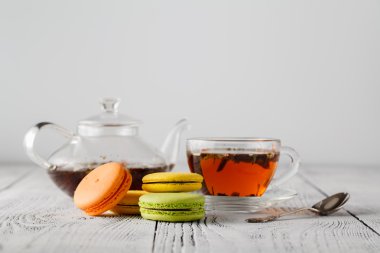 Renk ahşap tabloda çay ile renkli macaroons