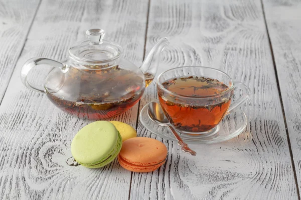 Édes és színes francia macaroons teáskanna és tea cup — Stock Fotó