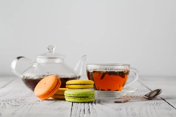 Színes macaroons csésze tea, színes fából készült asztal — Stock Fotó
