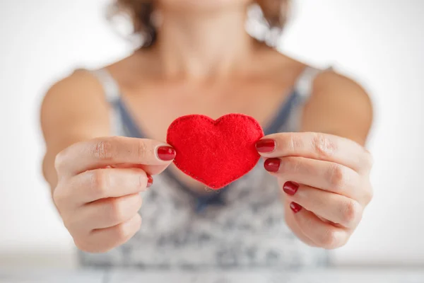 Woman holding a heart symbol in her hands — Stock Photo, Image