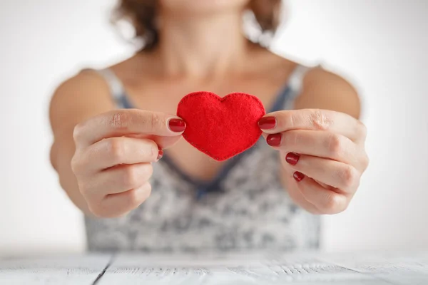 Woman holding a heart symbol in her hands — Stock Photo, Image
