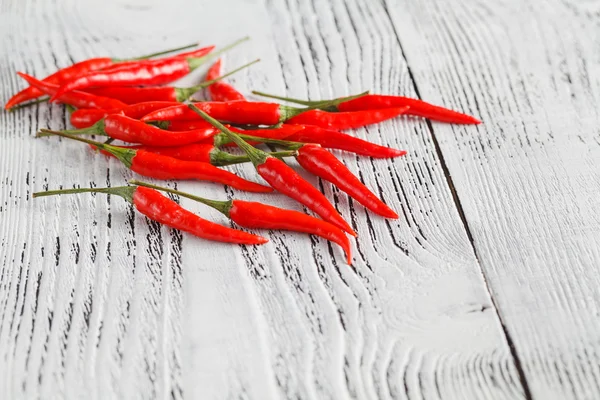 Quelques piments rouges sur une table en bois — Photo