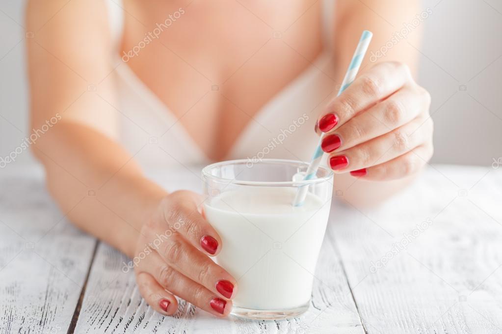 woman with a big glass of healthy smoothie served with a straw