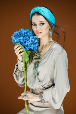 Uzun ve parlak dalgalı saçlı ve doğal makyajlı esmer kız.