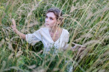 Güzel bir yaz kızı bir buğday tarlası, beyaz bir elbise güneşli bir gün. Gençlik modeli yaz tatili, tatil ve insanlar konsepti