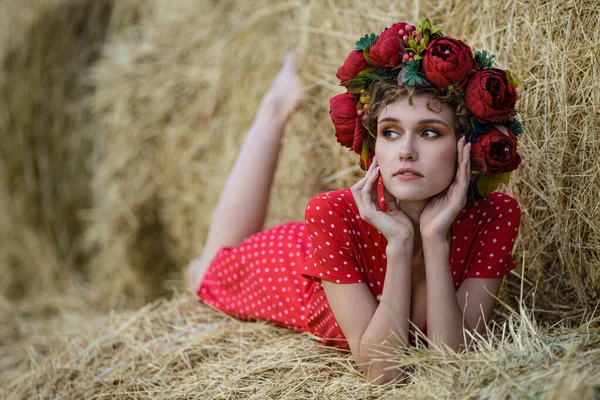 屋外の女性 干し草の背景にポーズをとった赤いドレスの若い可愛い女性 小麦畑で撮影されたコンセプト写真夏の夜遅く — ストック写真