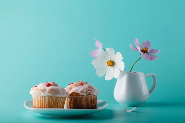 Fargerik muffin på tallerken med blomst – stockfoto