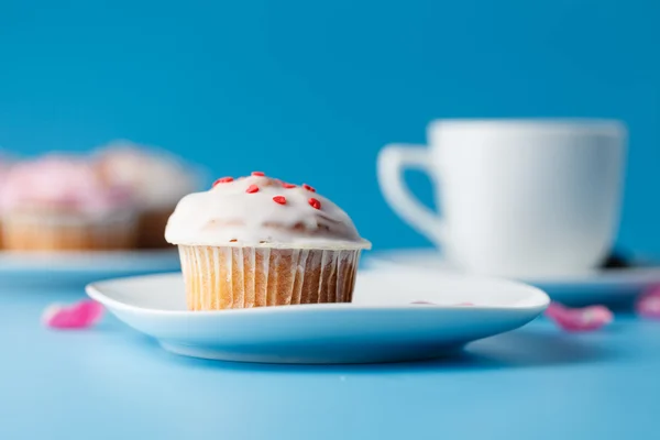 Fargerik muffin på tallerken med blomsterblad – stockfoto