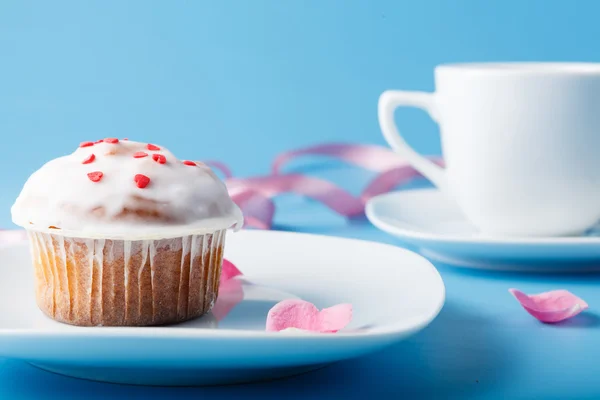 Bunter Muffin auf Untertasse mit Blütenblatt und Band — Stockfoto