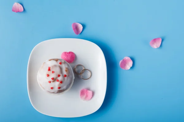 Bolinho no pires com alianças de casamento. Vista superior — Fotografia de Stock