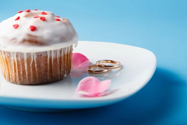 Muffin colorido en platillo con anillos de boda — Foto de Stock