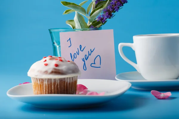 Muffin auf Untertasse mit Blütenblatt und Botschaft "ich liebe dich" — Stockfoto
