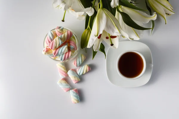 Xícara de chá, lírio branco, marshmallow colorido — Fotografia de Stock