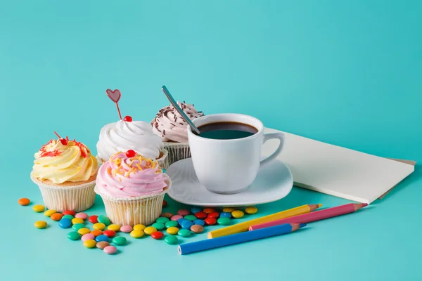 Cupcakes com confete colorido e xícara de café — Fotografia de Stock