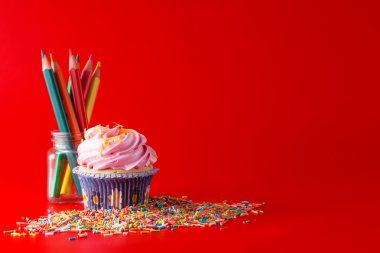 Brigth kırmızı arka plan üzerinde renkli cupcake