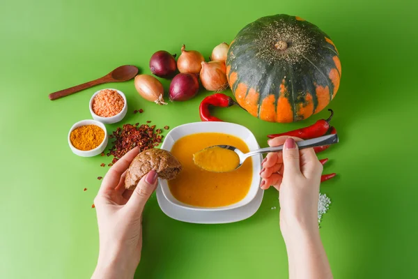 Sopa de abóbora com cebola e pimenta em backgroud sem sombra verde — Fotografia de Stock