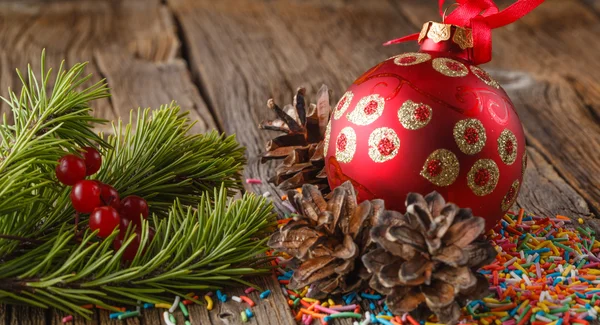 Christmas theme. Pine and red ball on wooden table — Stock Photo, Image