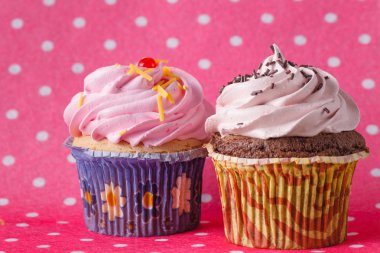 Renkli pembe artalanları üzerinde iki Cupcake