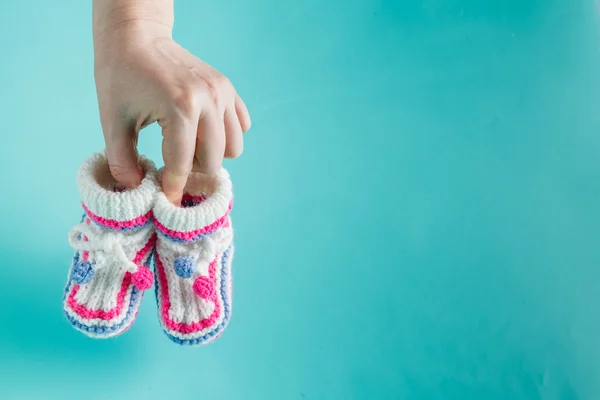 Main tenant de minuscules bottines tricotées — Photo
