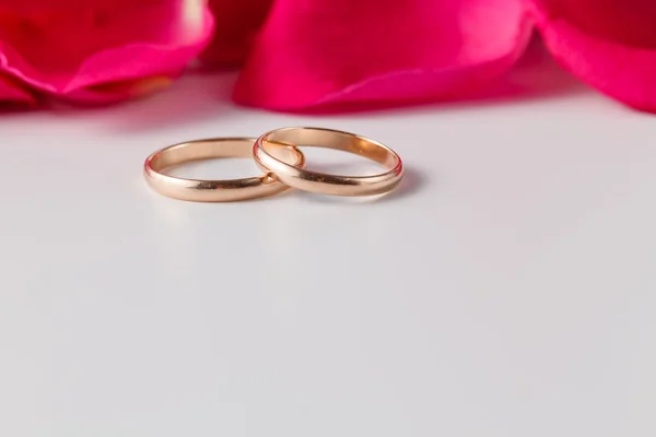 Anéis de casamento dourados com pétalas de rosa — Fotografia de Stock