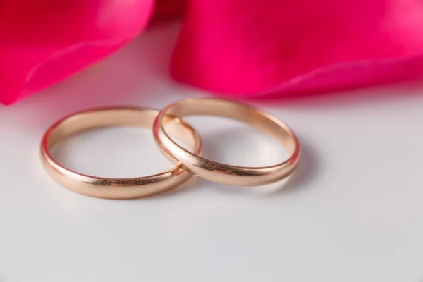 Golden wedding rings with rose petals — Stock Photo, Image