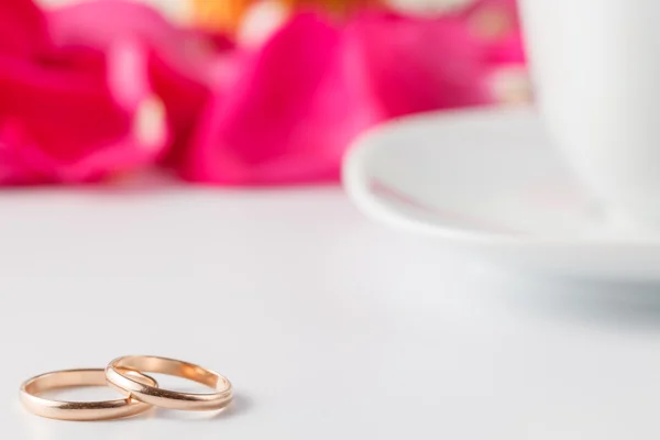 Anillos de boda dorados con pétalos de rosa — Foto de Stock